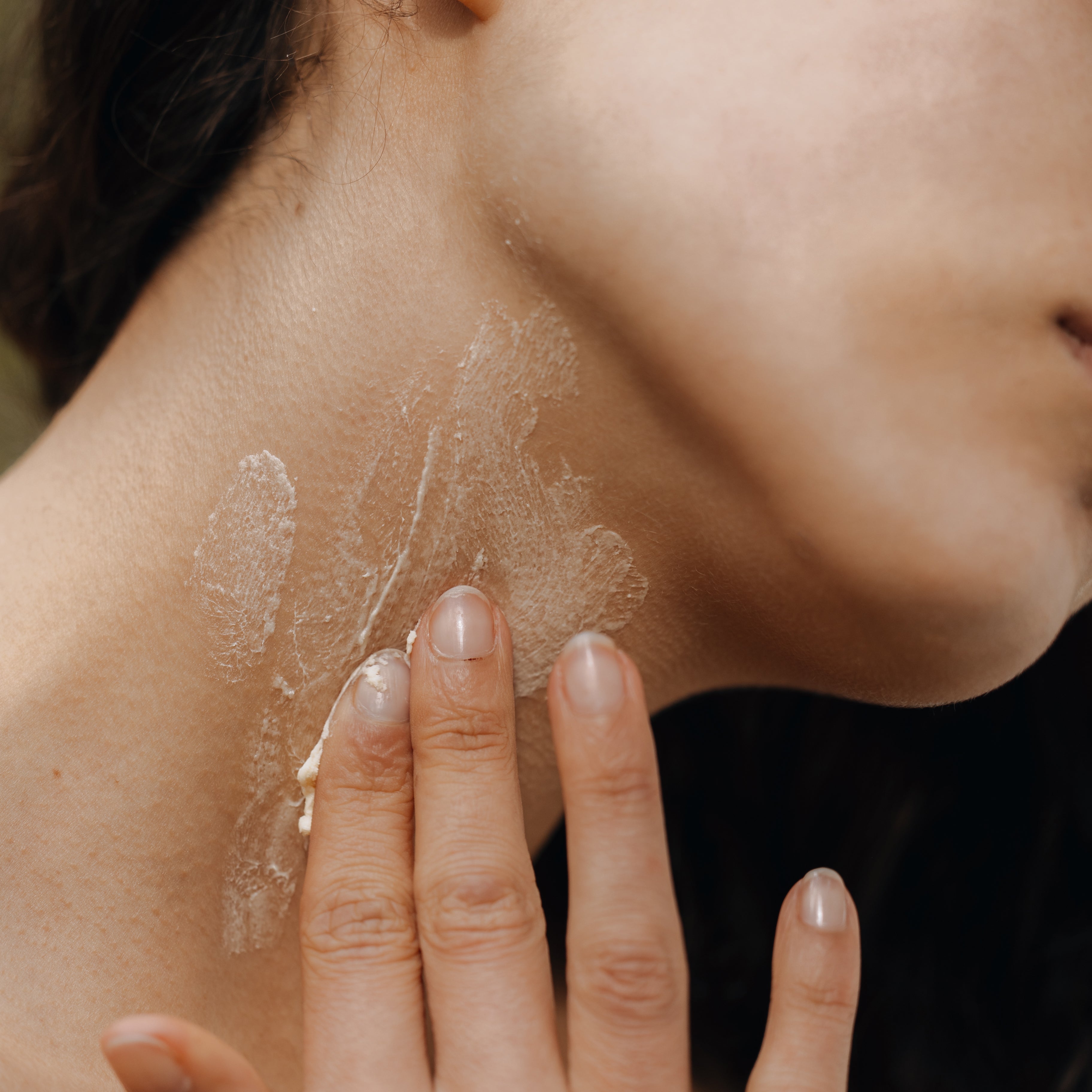 Neck of woman with cream on it