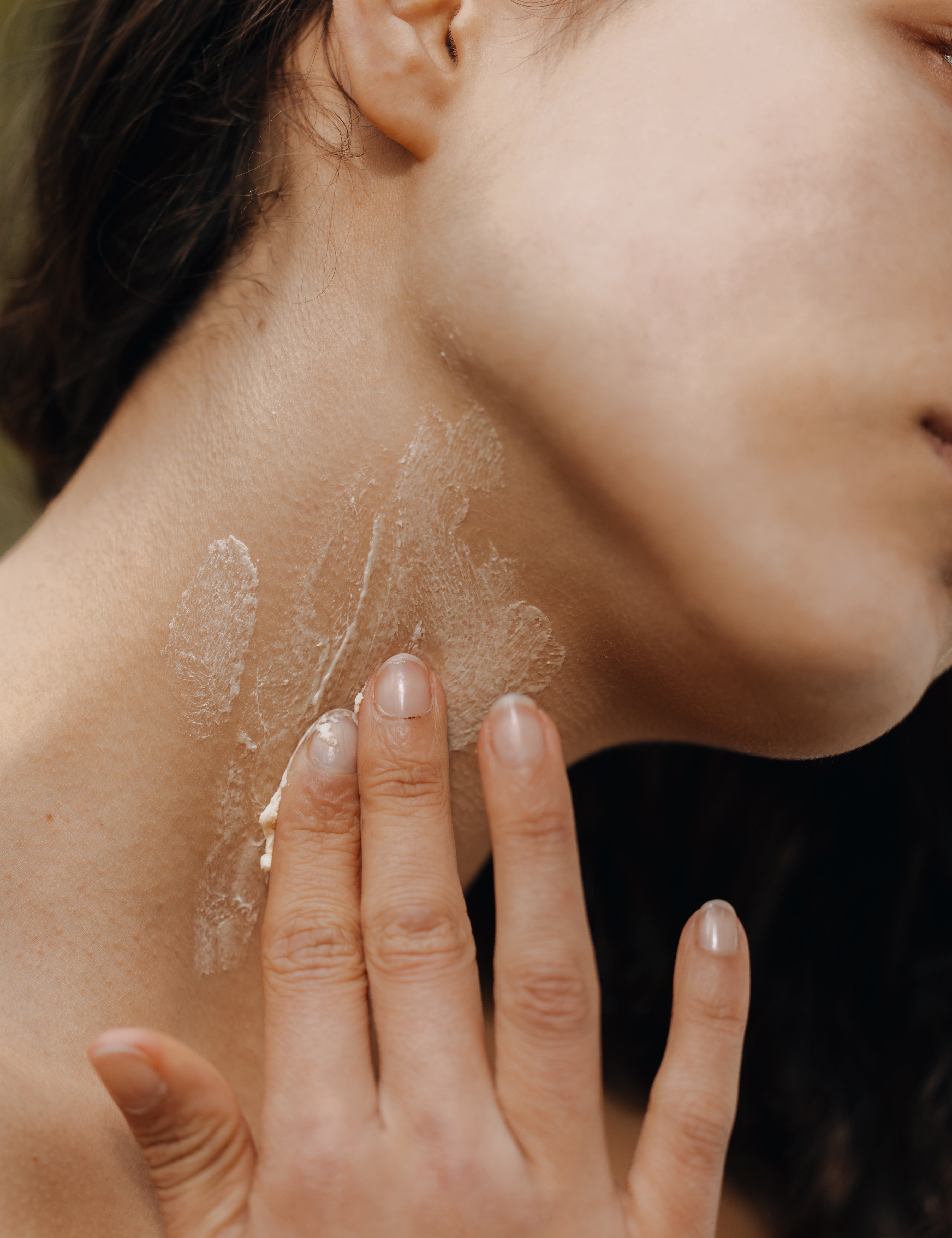 Neck of woman with cream on it