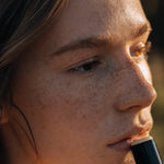 Close-up of a person holding a black object with a blurred background