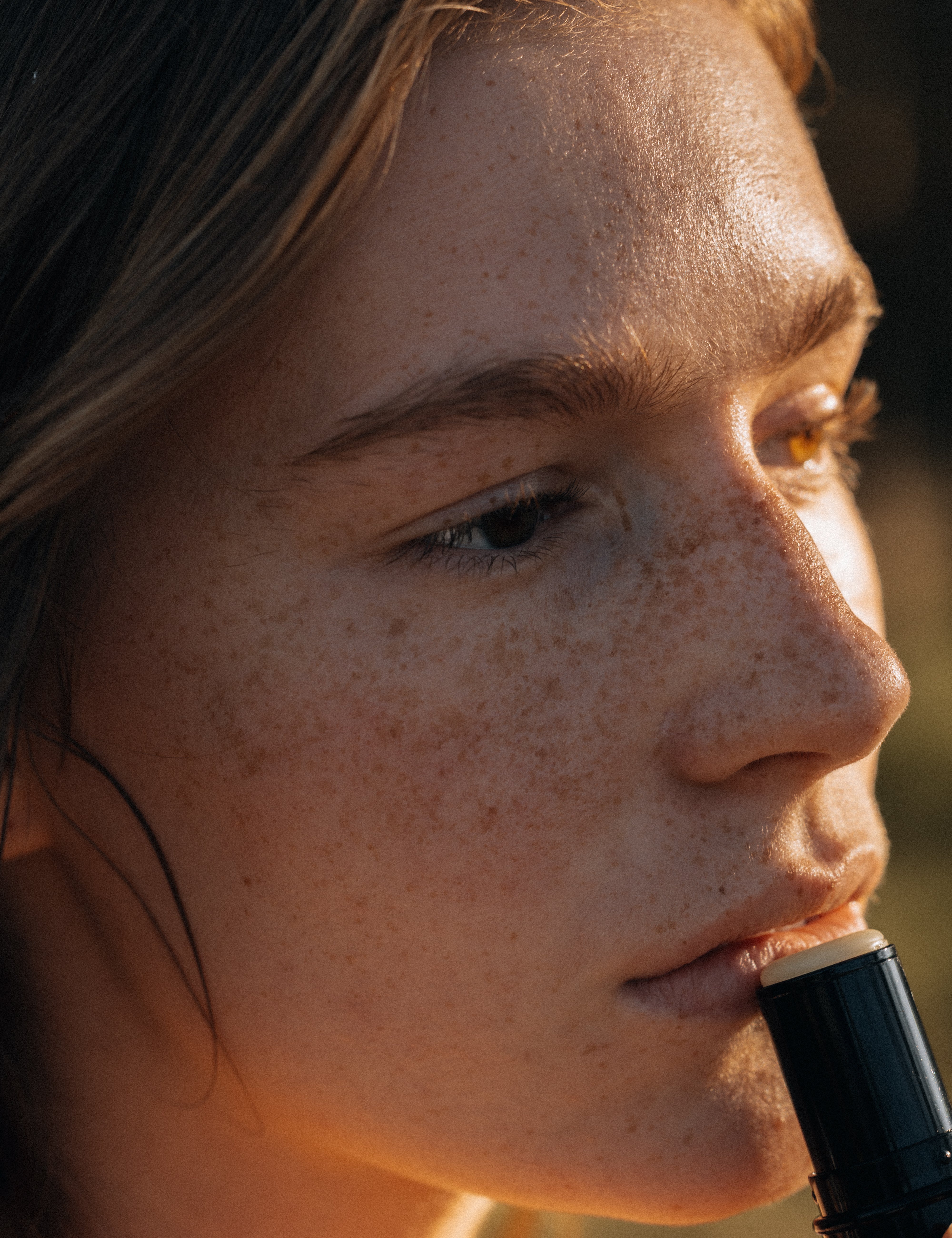 Close-up of a person holding a black object with a blurred background