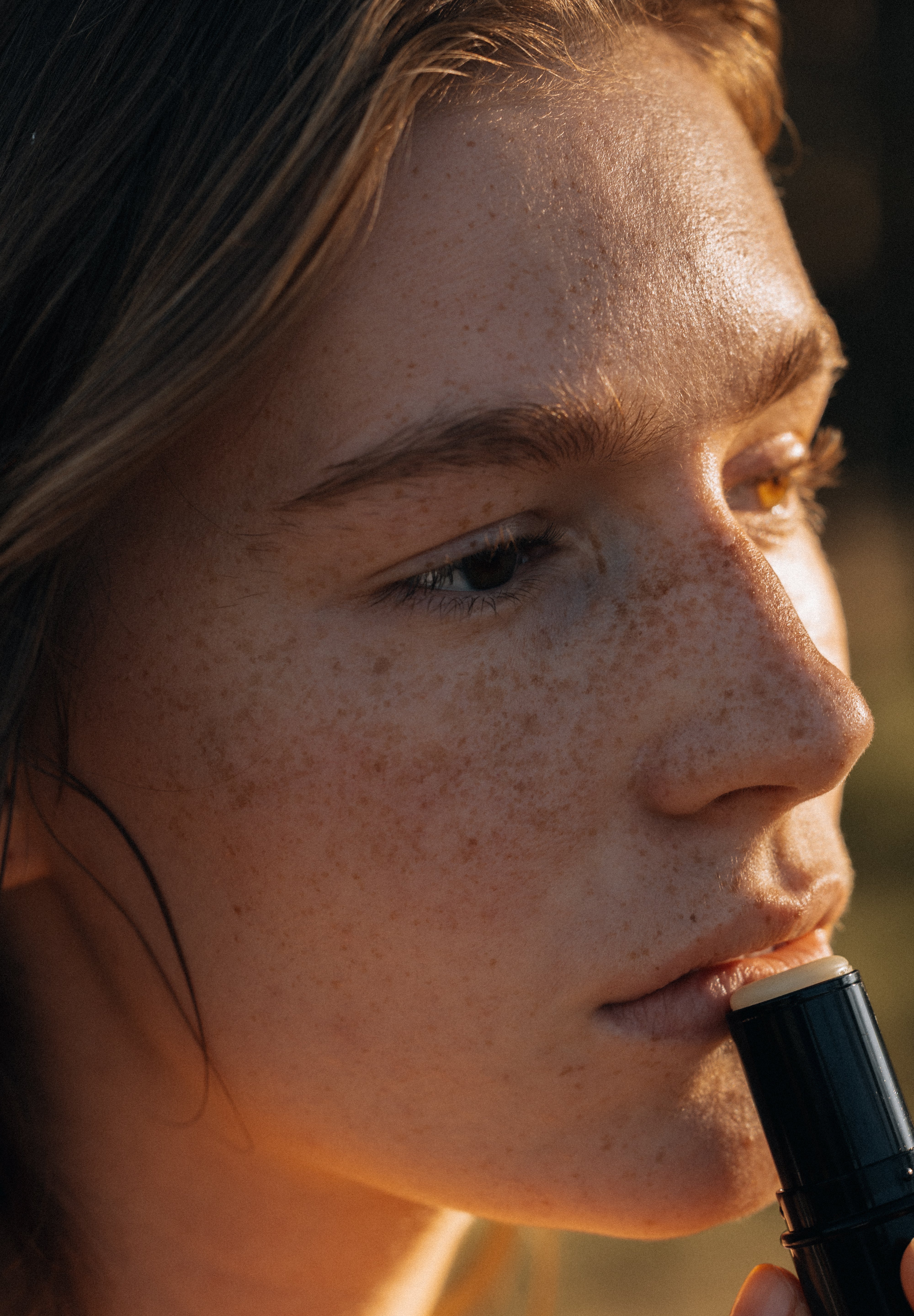 Close-up of a person holding a black object with a blurred background